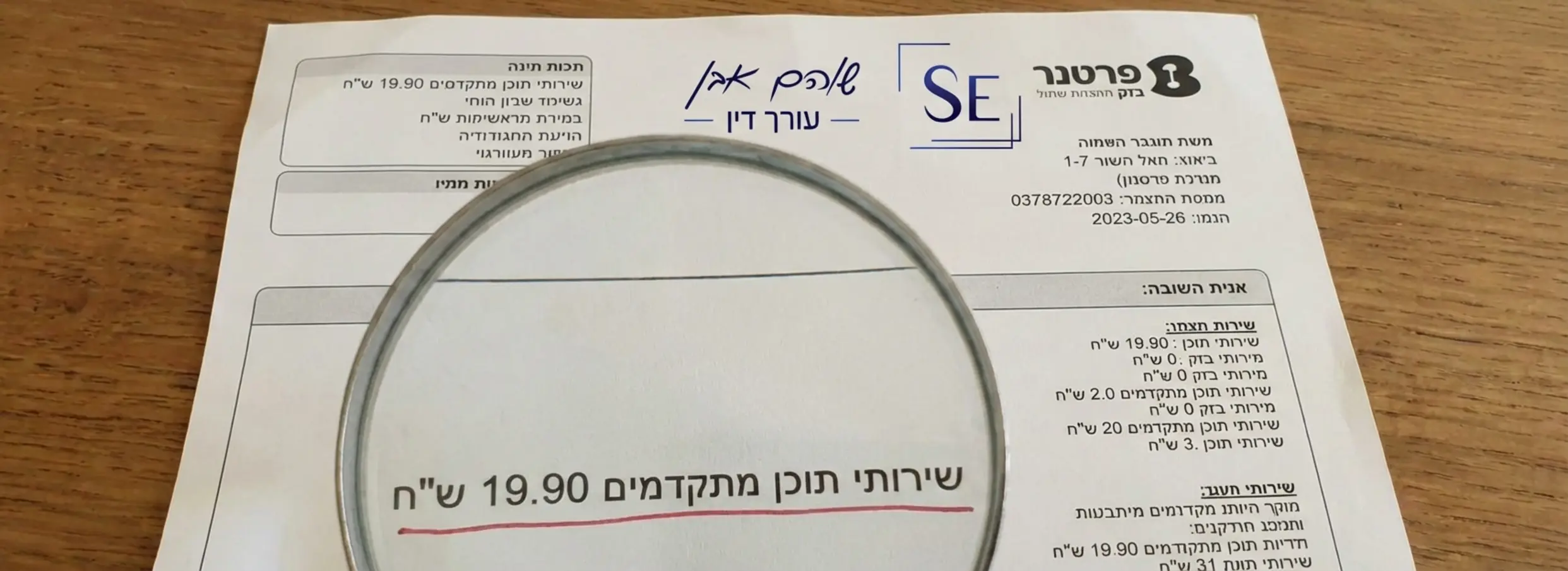 תמונה ריאליסטית של חשבונית תקשורת טיפוסית בעברית, כאשר זכוכית מגדלת מונחת על שורה קטנה ומודגשת באדום שכתוב בה שירותי תוכן מתקדמים 19.90 שח